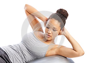 Pushing herself to get the best results. A gorgeous young woman doing exercises with a pilates ball.