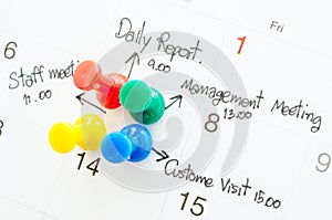Pushpin on calendar with busy day.