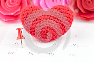 Pushpins on calendar and red heart