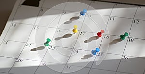 Pushpins or thumbtacks on calendar