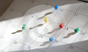 Pushpins or thumbtacks on calendar