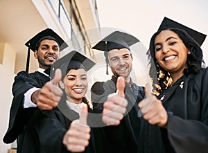 Put in as much effort as you can. Portrait of a group of students showing thumbs up on graduation day.