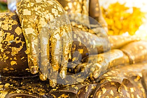 Put gold leaf onto The Buddha statue to gild. Which people use t photo