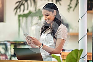 Put in those orders early. a florist using her smartphone to send a text message.