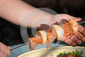 Put pieces of raw meat on skewers.Photo cooking shish kebab,BBQ, barbecue, shashlik or meat. Cooking meat in the grill on skewers