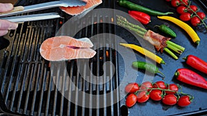 Put the salmon steak on the grill. Grilled vegetables with steak fish