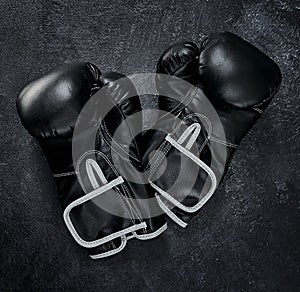 Put your hands up. High angle shot of a pair of boxing gloves placed together on top of a dark background inside of a