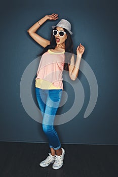 Put your party pants on an let loose. Studio shot of an attractive and fun loving young woman posing against a dark