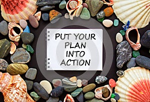 Put your plan into action symbol. Concept words Put your plan into action on beautiful black background. Sea stones and seashells