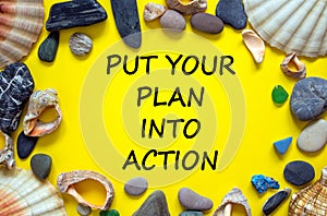 Put your plan into action symbol. Concept words Put your plan into action on beautiful yellow background. Sea stones and seashells