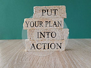 Put your plan into action symbol. Concept words Put your plan into action typed on brick blocks