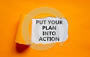 Put your plan into action symbol. Concept words Put your plan into action on white paper on a beautiful orange background.