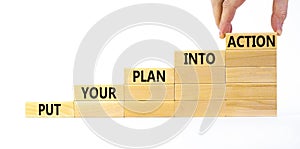 Put your plan into action symbol. Wooden blocks with words Put your plan into action. Beautiful white background, copy space.