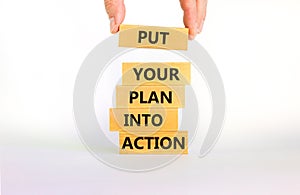 Put your plan into action symbol. Wooden blocks with words Put your plan into action. Beautiful white background, copy space.