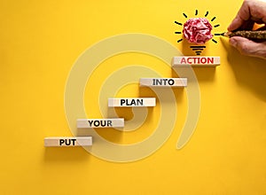 Put your plan into action symbol. Wooden blocks with words Put your plan into action. Beautiful yellow background, copy space.