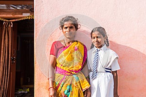 PUTTAPARTHI, ANDHRA PRADESH, INDIA - JULY 9, 2017: Indian woman in sari and girl in school uniform. Copy space for text. Close-up.
