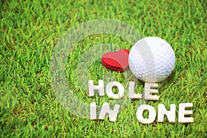 Putter and golf ball on green background