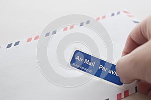 Putting air mail tag on envelope