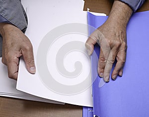 Putting away paper in a folder for organization ,work,order and future reference