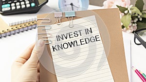 putting a card with text Invest In Knowledge in the pocket
