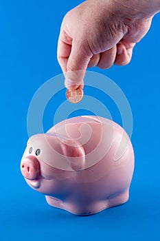 Putting a coin in a piggy bank photo
