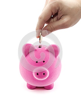 Putting coin into the piggy bank