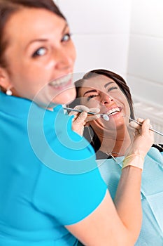 Putting dental braces to the woman`s teeth at the dental office. Dentist examine female patient with braces in dental