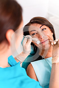 Putting dental braces to the woman`s teeth at the dental office. Dentist examine female patient with braces in dental