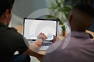 Putting the focus on finance. two young businessmen using a laptop with graphs on the screen during a meeting in a