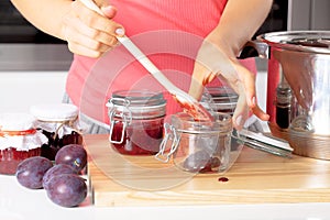 Putting fresh jams into a jars