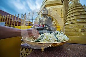 Putting garland in front of the Buddha image for respectation