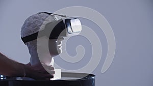 Putting a greek head sculpture in VR glasses on the stand