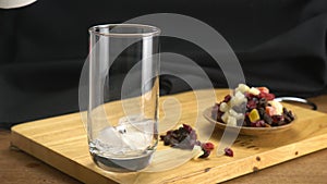 Putting ice cubes into transparent glass.