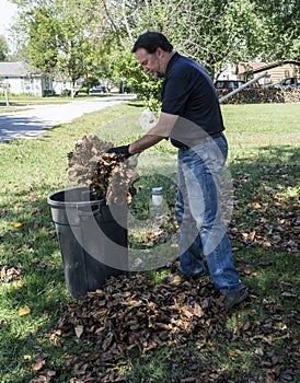 Putting Leaves In A Trash Can