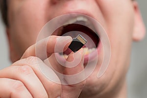 Putting micro SDHC memory card into the mouth - shallow focus