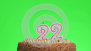 Putting a number twenty two birthday candle on a delicious cake, green screen 22