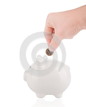 Putting one euro coin into piggy bank