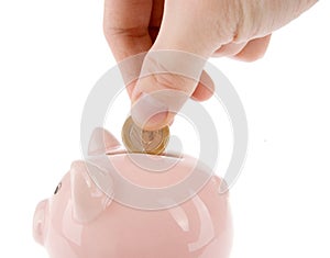 Putting one euro coin into piggy bank