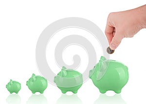 Putting one euro coin into piggy bank growing savings concept