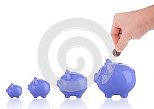 Putting one euro coin into piggy bank growing savings concept