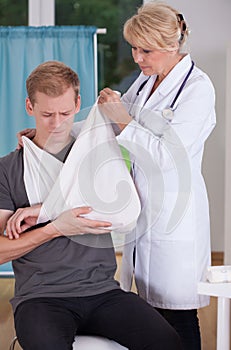 Putting on sling to patient's hand