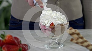 Putting sweet cream onto a cup of ice cream