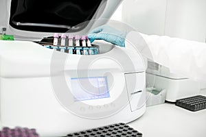 Putting test tubes into the holder of analyzer machine