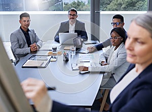 Putting their minds to work on something new. Shot of a group of businesspeople listening to a presentation in an office