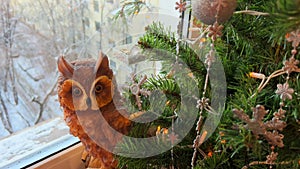 Putting toy owl under Christmas tree. Decorating home in winter. Xmas decor on window sill. POV arrange Christmas tree