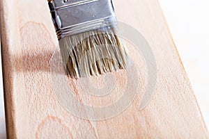 Putting varnish on beach wooden board