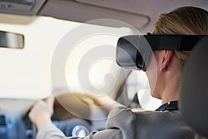 Putting virtual reality in the drivers seat. a young businesswoman driving while wearing a virtual reality headset.