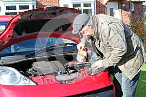 Putting water into a car radiator.