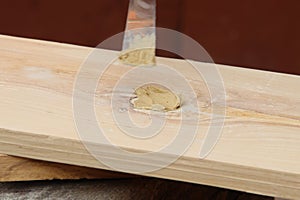 Putty knife in old man`s hand. Removing paint from a wood surface. Preparation of boards before impregnation with