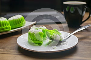 Putu ayu cake slices on a spoon on a laptop background looks blurry